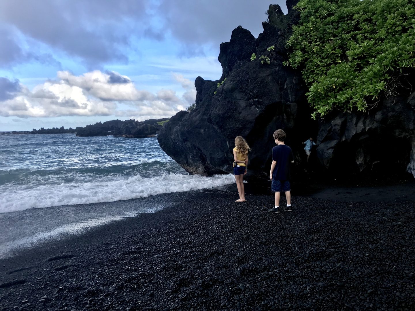 Grace and Jonah on the black sand beach alongside a lava tube at Wai’anapanapa State Park